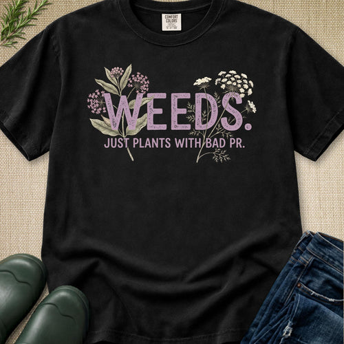 Weeds Just Plants With Bad PR t-shirt featuring Milkweed and Queen Anne's Lace botanical illustrations on a vintage washed black shirt.